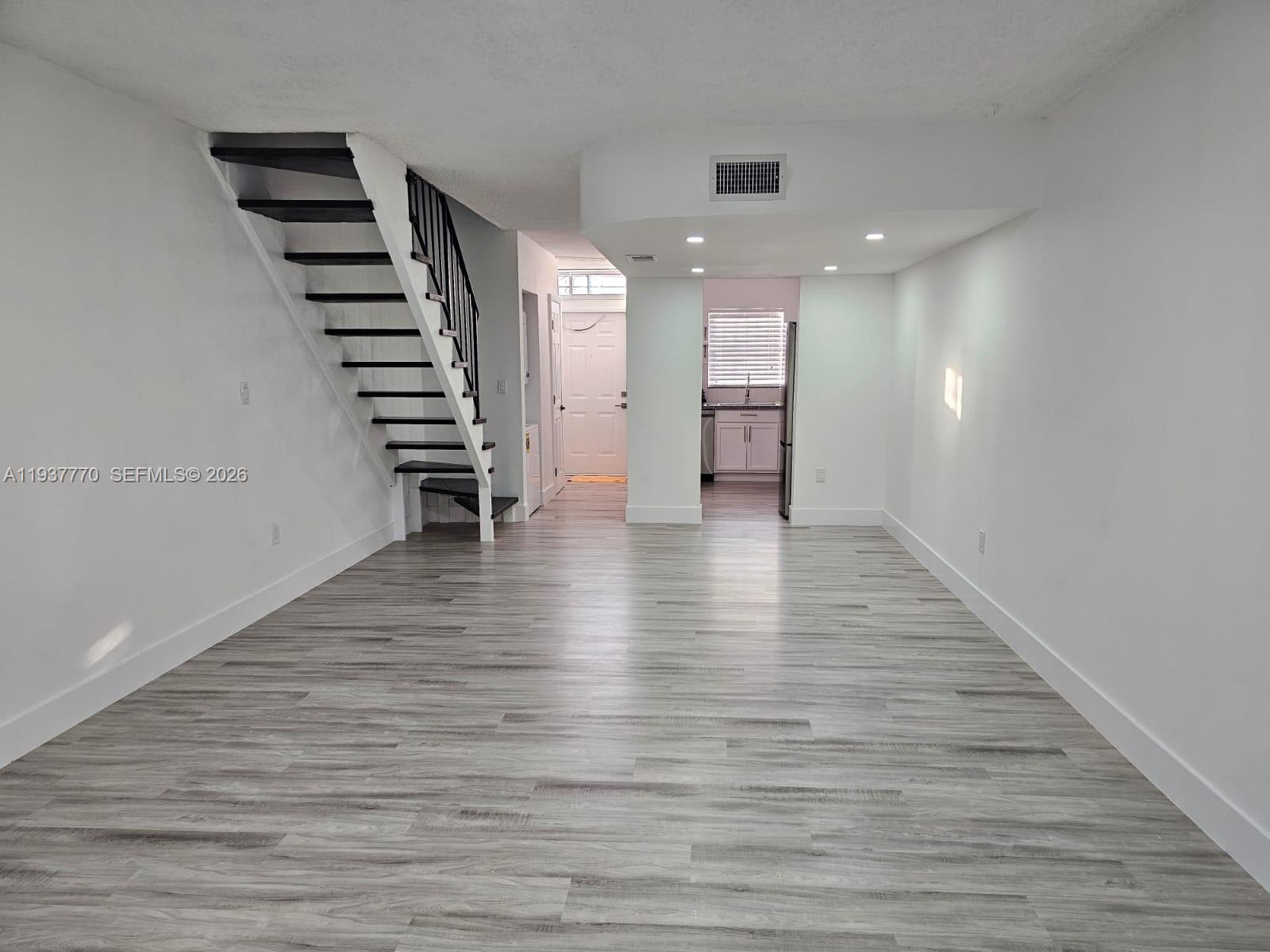4357 West 11th Lane, Unit 55 Hialeah, FL 33012 - Photo 2 of 17 a view of an empty room with wooden floor