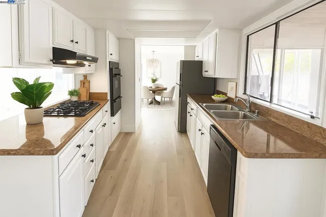 a kitchen with stainless steel appliances granite countertop a sink a stove and a refrigerator