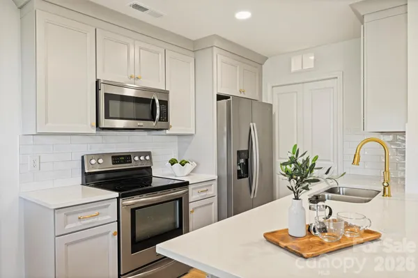 a kitchen with stainless steel appliances a microwave a sink a refrigerator and a counter space