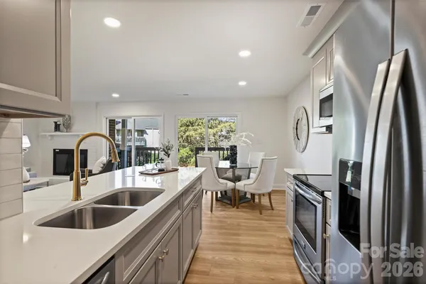 a view of kitchen with microwave stove refrigerator dining table and chairs