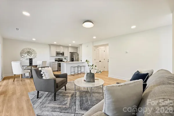 a living room with furniture and view of kitchen