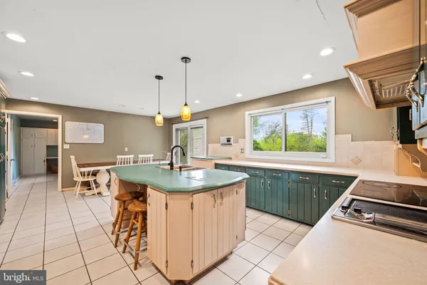 a kitchen with a sink a counter and chairs