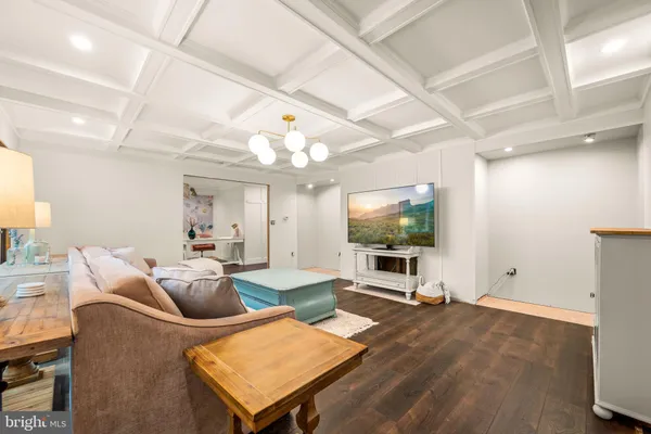 a living room with furniture a flat screen tv and kitchen view