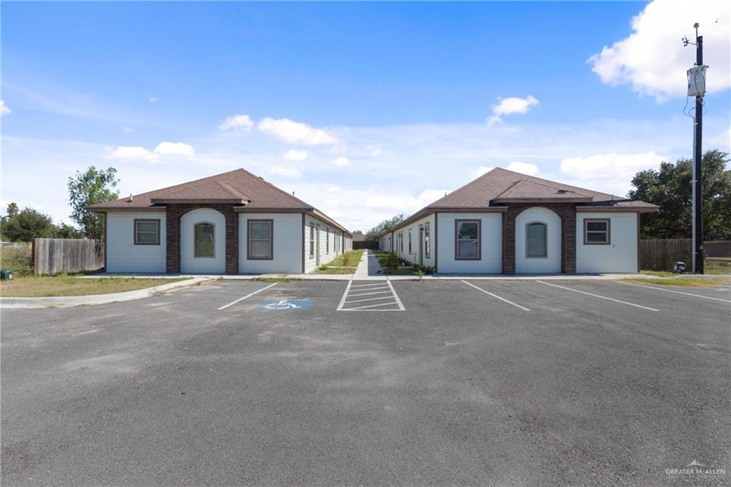 a view of a house with a yard and potted plants