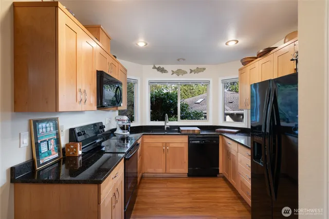 a kitchen with stainless steel appliances granite countertop refrigerator a sink a stove top oven and cabinets