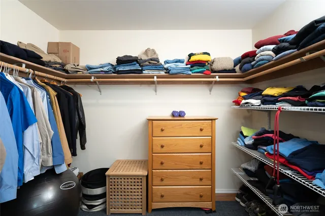 a view of walk in closet with clothes and shoes