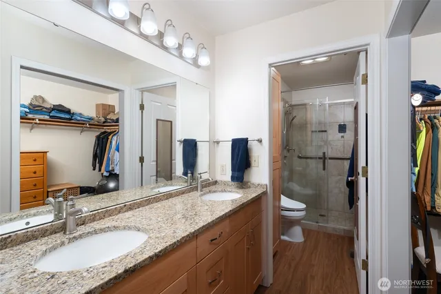 a bathroom with a granite countertop sink a mirror and shower
