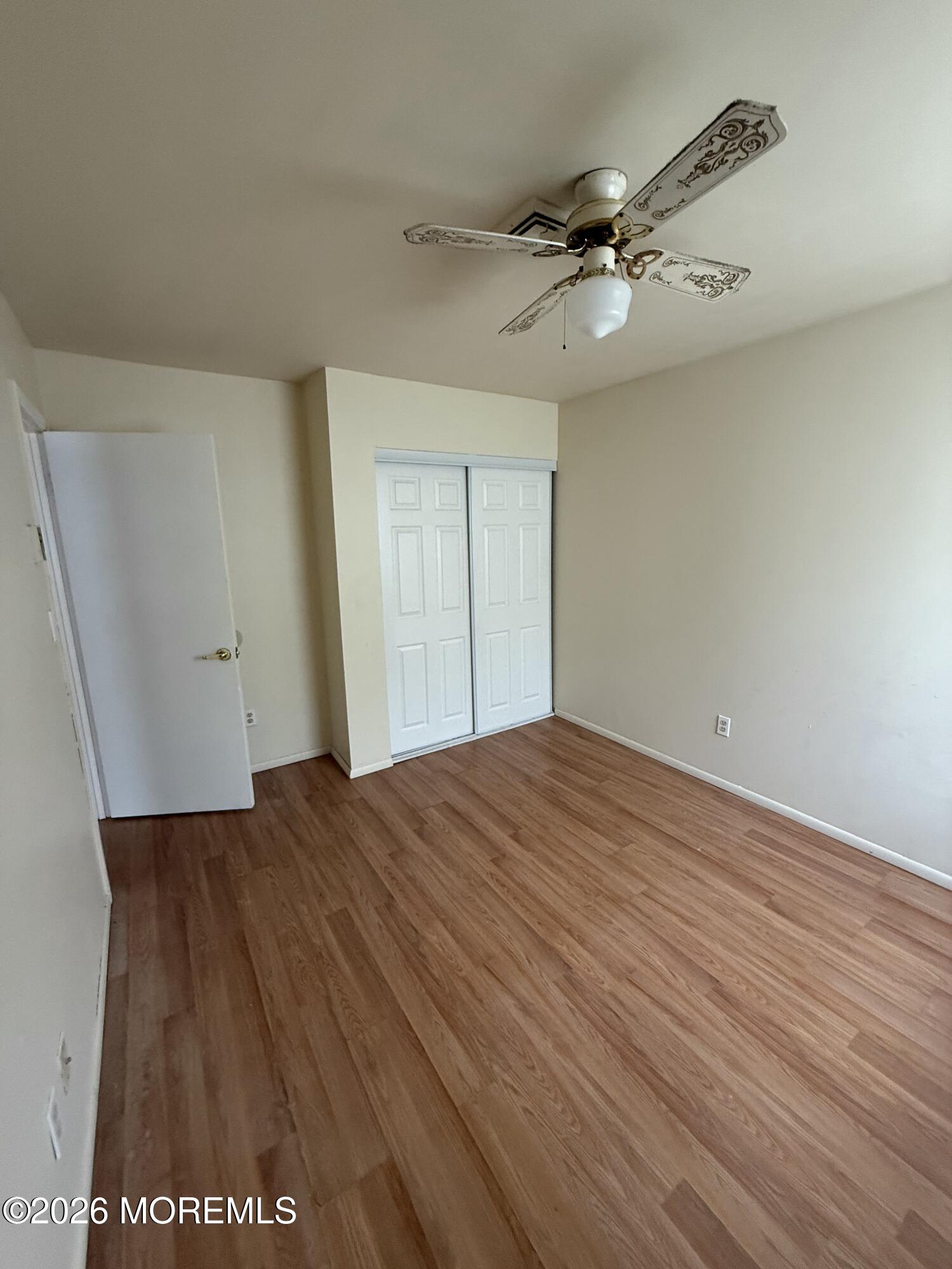 7 Sovereign Road Barnegat, NJ 08005 - Photo 7 of 7 an empty room with wooden floor and fan