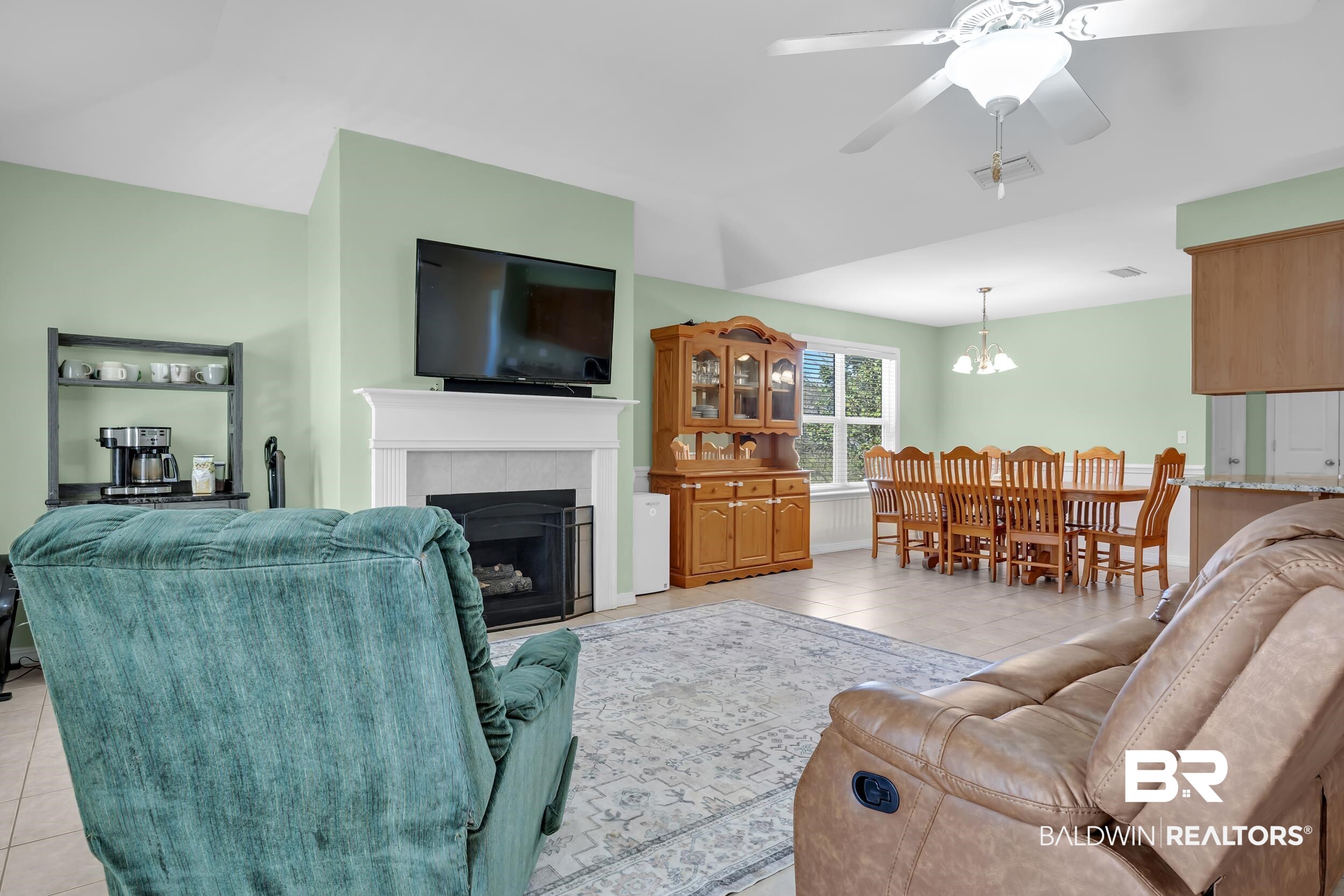 31527 Heidelbrook Loop Daphne, AL 36527 - Photo 4 of 22 Living area featuring a ceiling fan, light tile patterned floors, a tile fireplace, and hanging lights