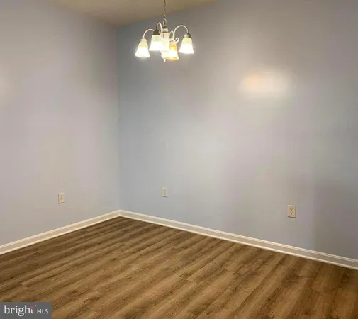 a view of a room with wooden floor and chandelier