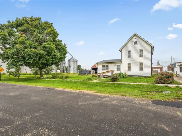 a view of a house with a big yard and large trees