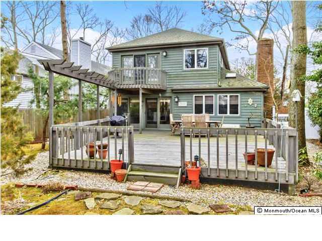 2403 River Road Point Pleasant, NJ 08742 - Photo 19 of 25 a view of a white house with large windows and a small yard