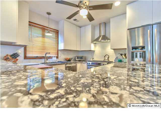 2403 River Road Point Pleasant, NJ 08742 - Photo 8 of 25 a kitchen with granite countertop a stove a sink and a refrigerator