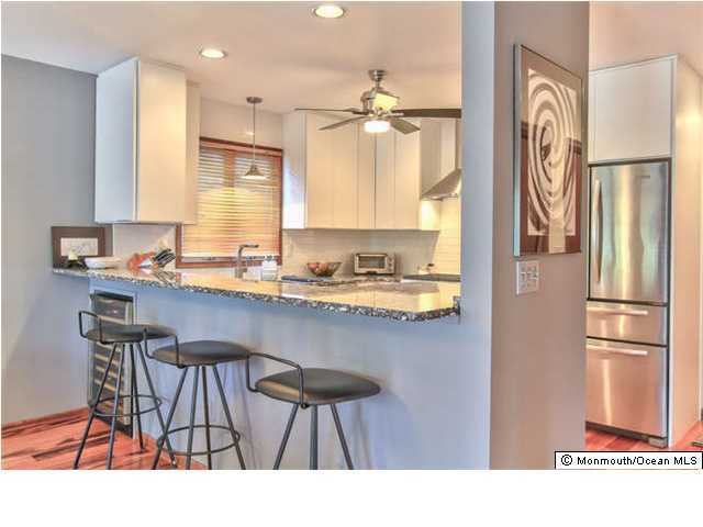2403 River Road Point Pleasant, NJ 08742 - Photo 10 of 25 a kitchen with a table chairs refrigerator and cabinets