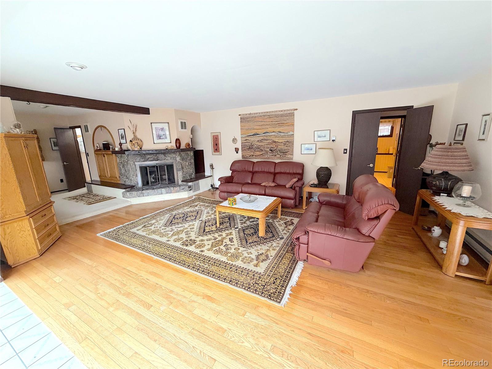 2508 Witter Gulch Road Evergreen, CO 80439 - Photo 23 of 47 a living room with furniture window and a fireplace