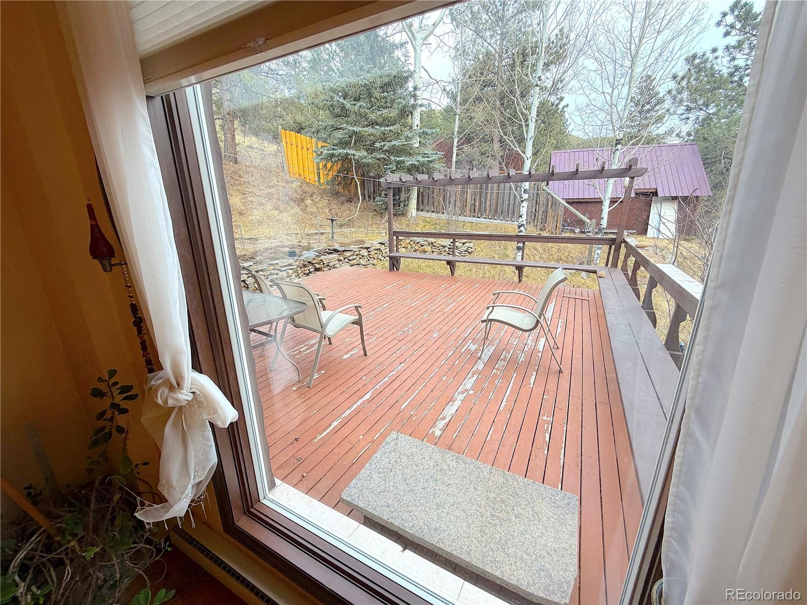2508 Witter Gulch Road Evergreen, CO 80439 - Photo 28 of 47 a view of a balcony with floor to ceiling windows with wooden floor