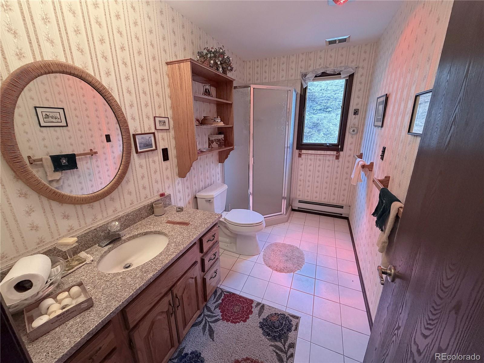 2508 Witter Gulch Road Evergreen, CO 80439 - Photo 38 of 47 a bathroom with a granite countertop toilet a sink and a mirror