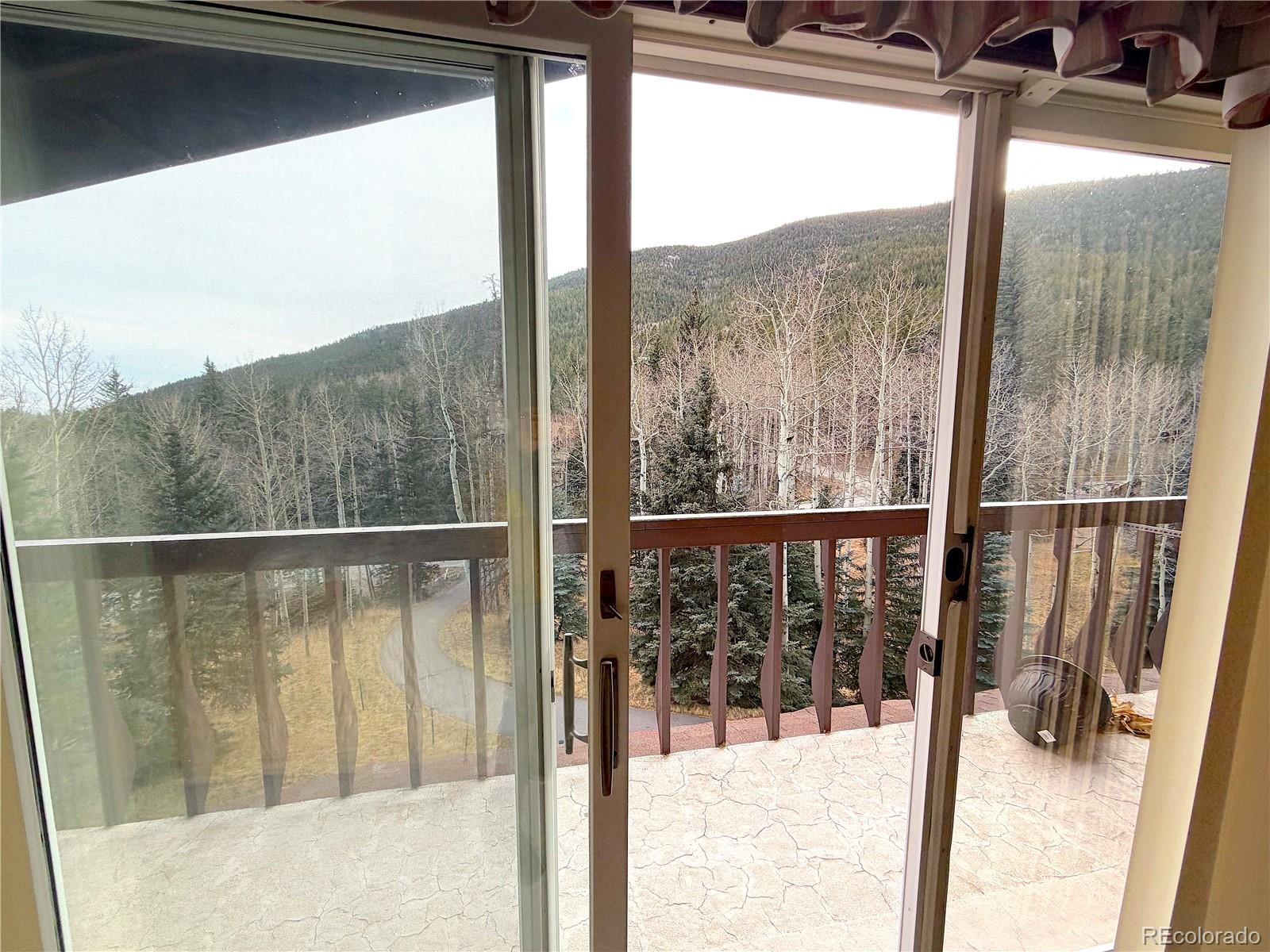 2508 Witter Gulch Road Evergreen, CO 80439 - Photo 41 of 47 a view of a balcony with a floor to ceiling window