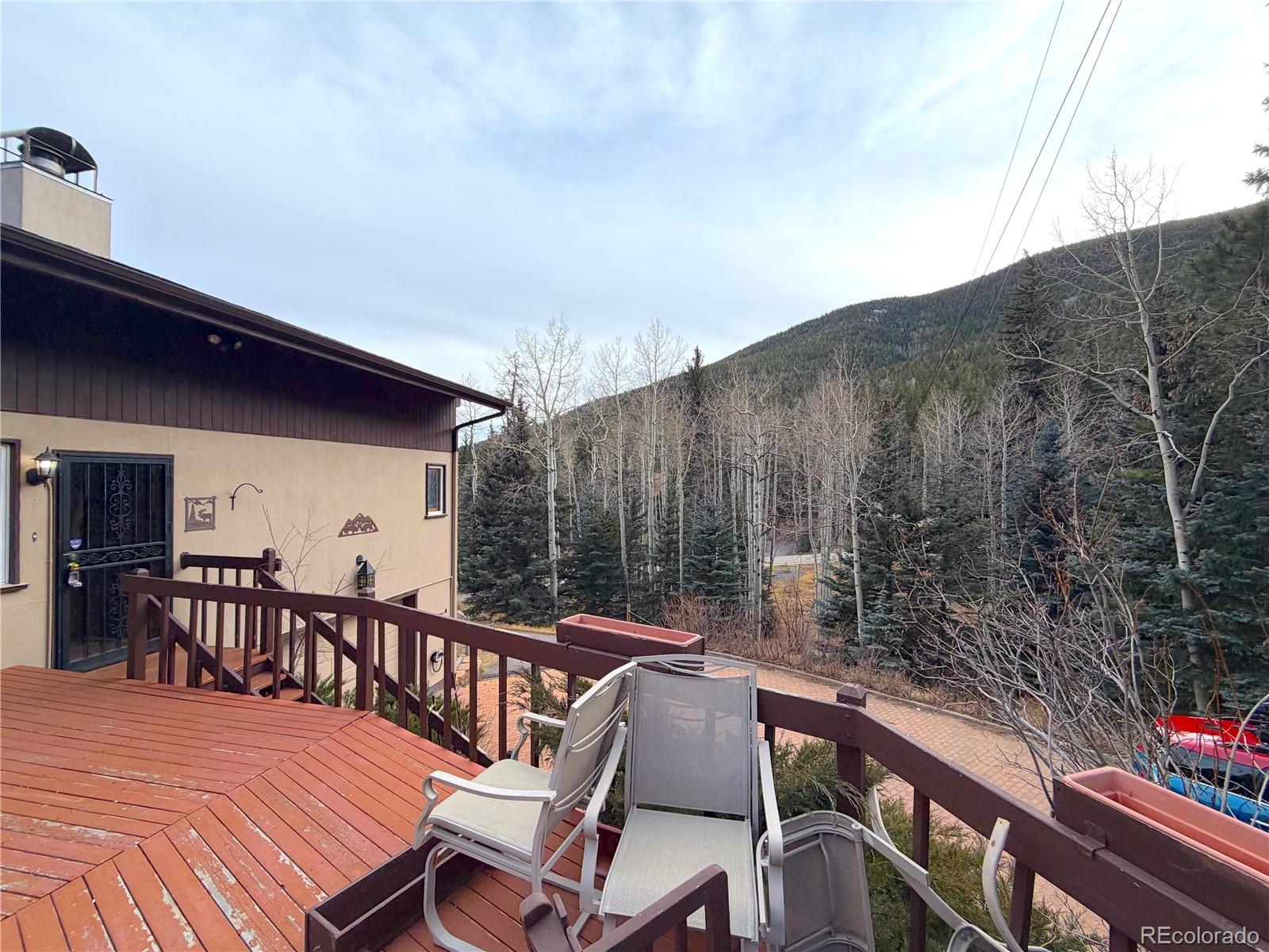 2508 Witter Gulch Road Evergreen, CO 80439 - Photo 10 of 47 a balcony with wooden floor table and chairs