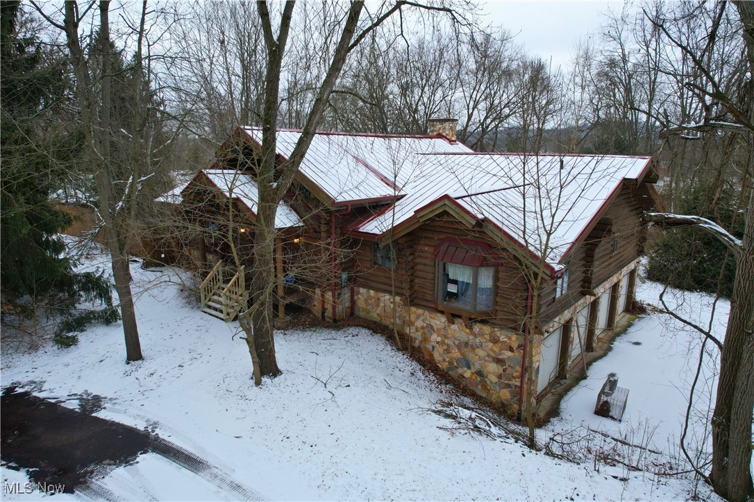 8026 Lee Road Northwest Malvern, OH 44644 - Photo 28 of 44 View of front of house with a chimney, stone siding, log siding, and a wooden deck