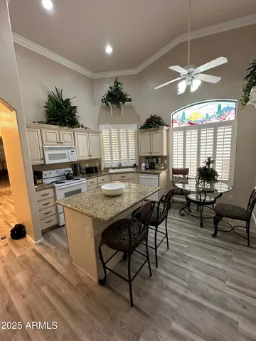 a kitchen with stainless steel appliances kitchen island granite countertop a table chairs and a refrigerator