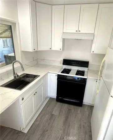 a kitchen with a sink a stove and cabinets