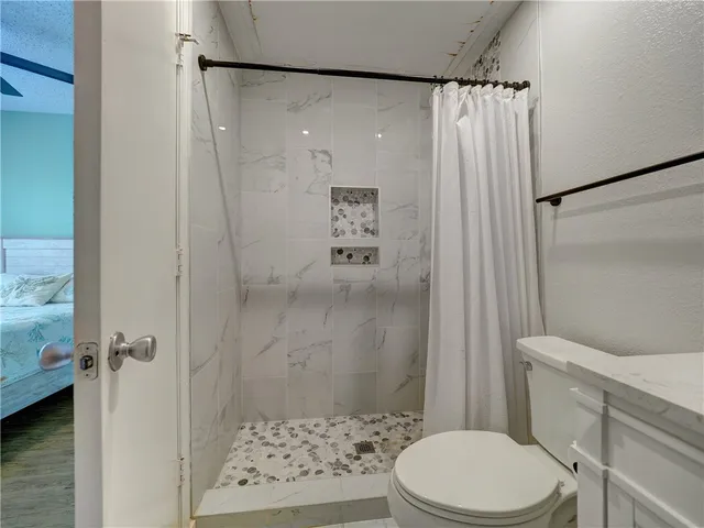 a bathroom with a shower a toilet and a shower