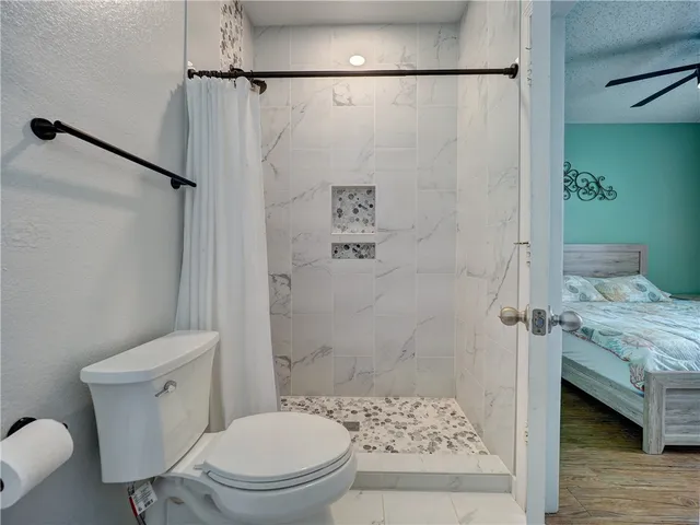 a bathroom with a toilet and a shower