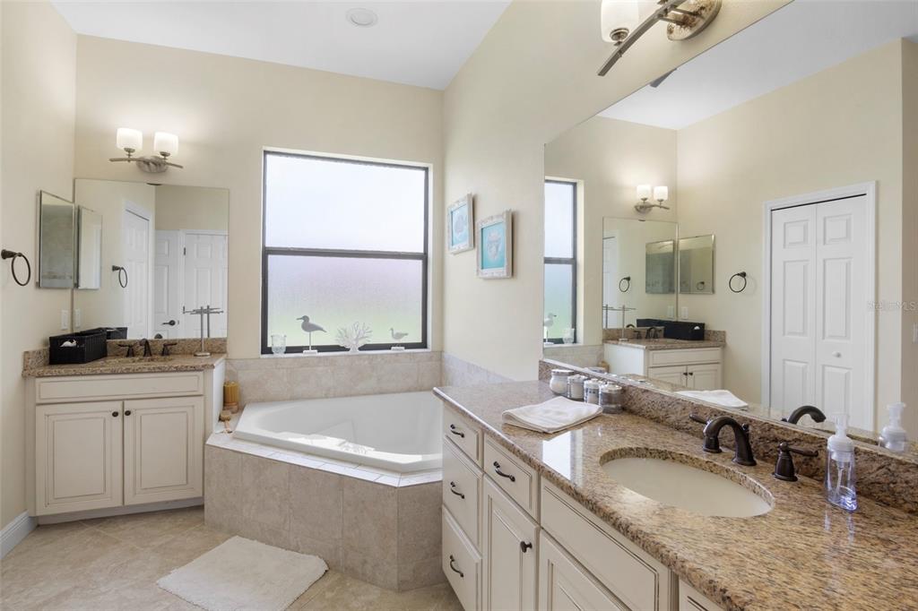 3511 Twin Rivers Trail Parrish, FL 34219 - Photo 18 of 43 a bathroom with a granite countertop tub sink and mirror