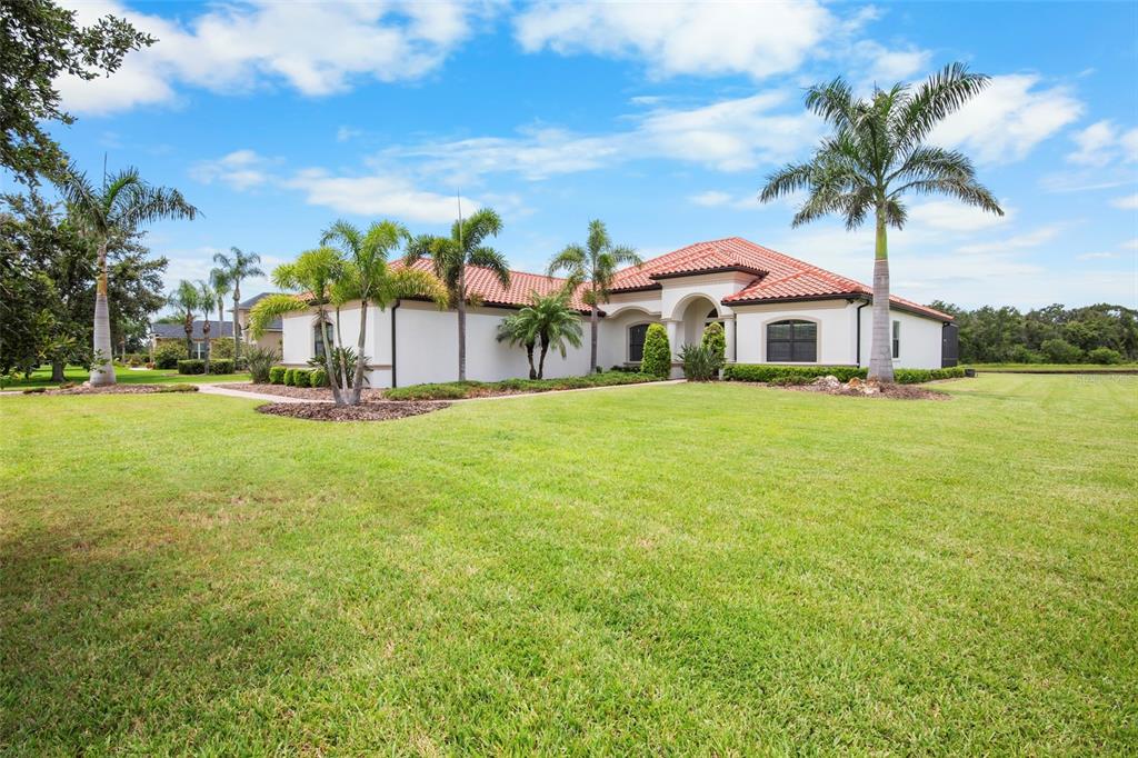 3511 Twin Rivers Trail Parrish, FL 34219 - Photo 2 of 43 a front view of a house with a garden and trees