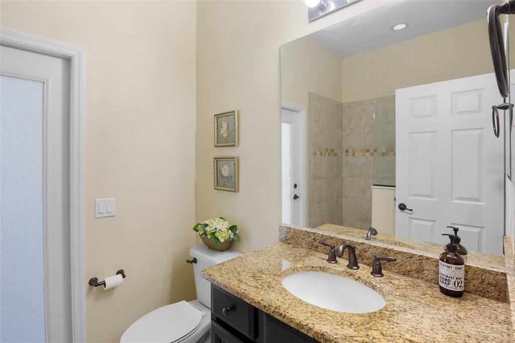 3511 Twin Rivers Trail Parrish, FL 34219 - Photo 21 of 43 a bathroom with a granite countertop sink a toilet and a mirror