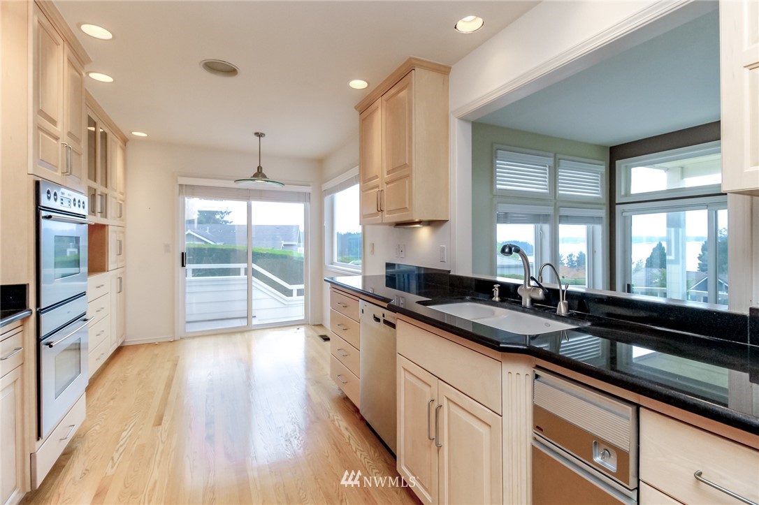 152 Cormorant Drive Steilacoom, WA 98388 - Photo 21 of 40 a large kitchen with granite countertop a large window and wooden floor