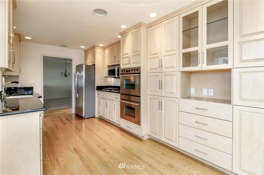 152 Cormorant Drive Steilacoom, WA 98388 - Photo 23 of 40 a kitchen with stainless steel appliances kitchen island granite countertop a refrigerator and cabinets
