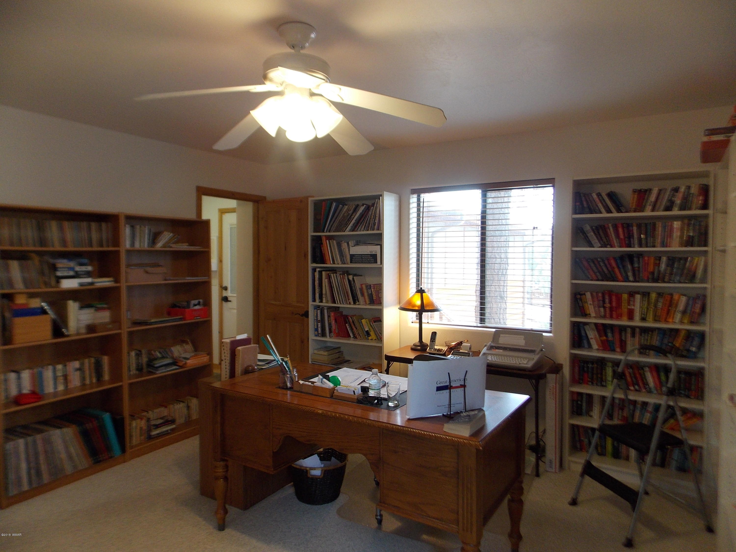 2296 Sunrise Road Overgaard, AZ 85933 - Photo 12 of 66 a view of a workspace with furniture and a bookshelf
