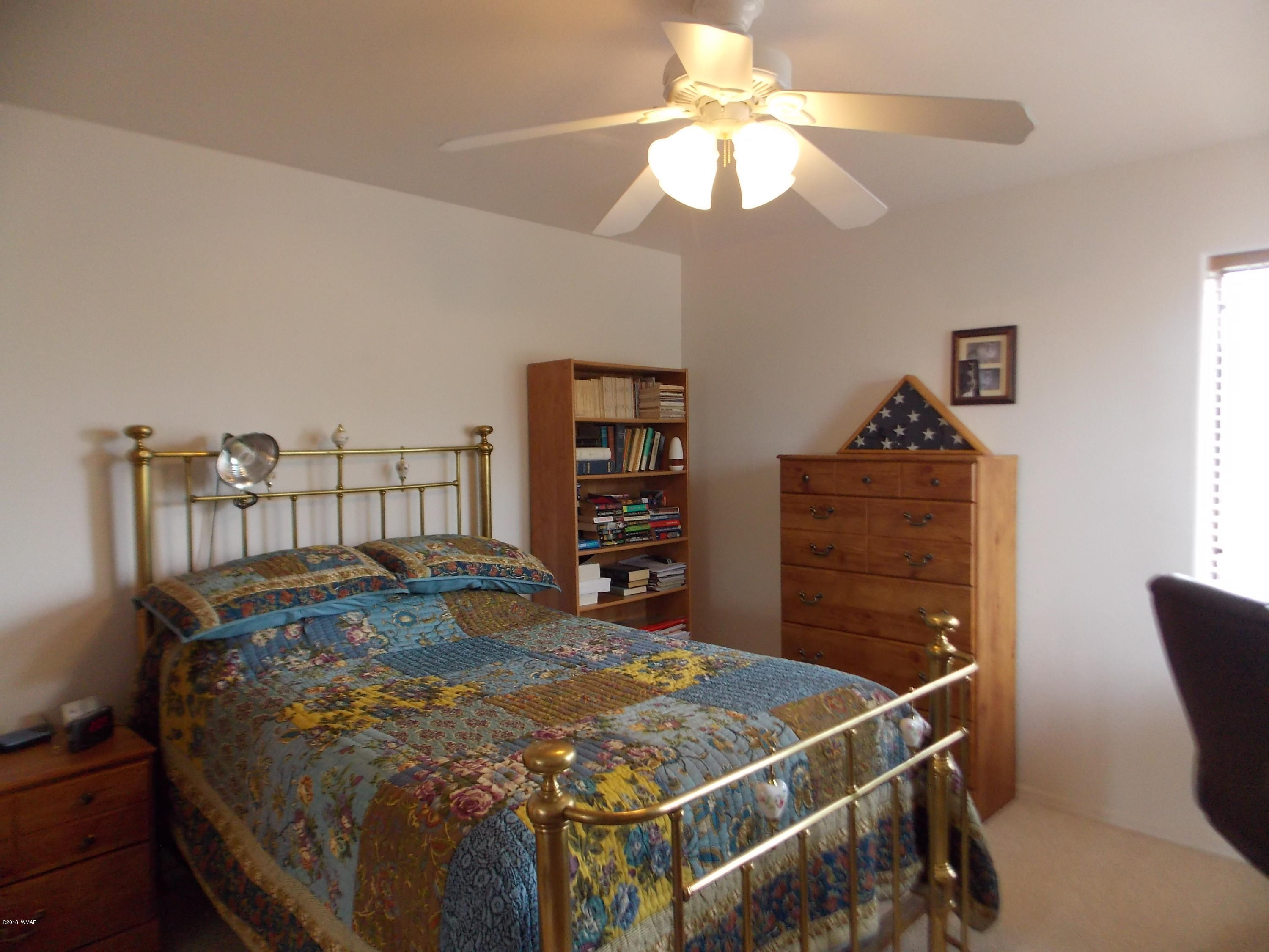 2296 Sunrise Road Overgaard, AZ 85933 - Photo 16 of 66 a bed sitting in a bedroom next to a cabinet