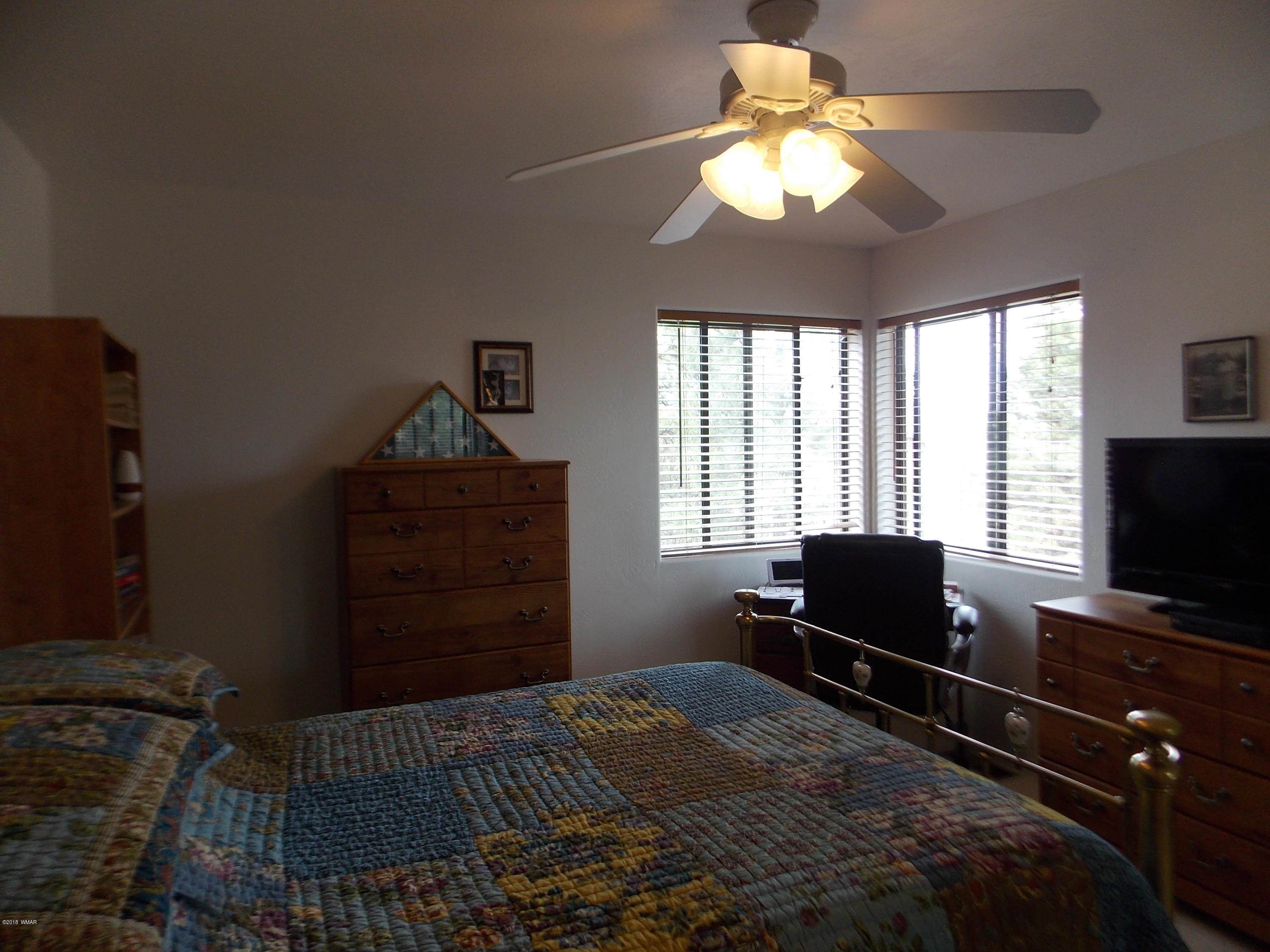 2296 Sunrise Road Overgaard, AZ 85933 - Photo 17 of 66 a bedroom with a bed and a television