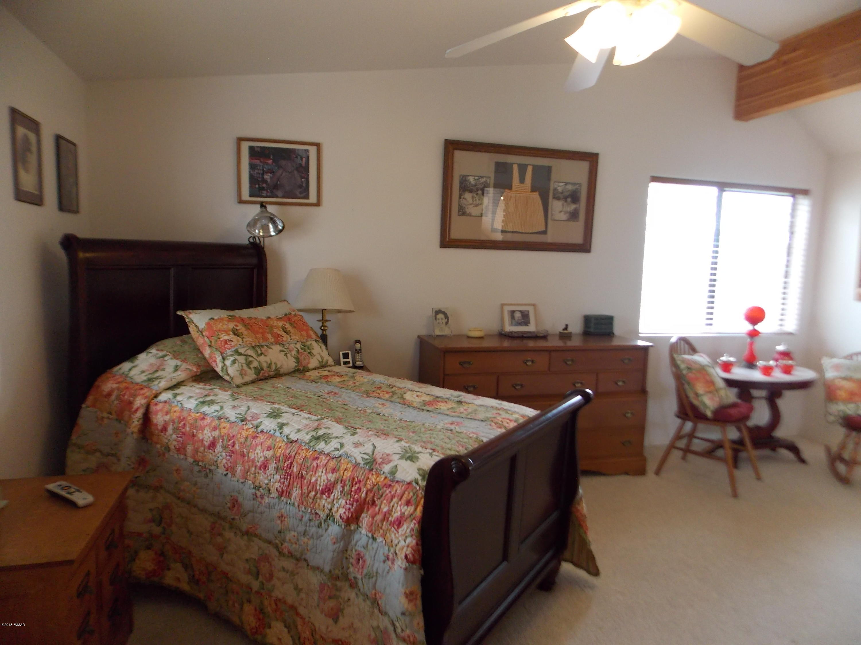2296 Sunrise Road Overgaard, AZ 85933 - Photo 24 of 66 a bedroom with a bed and a table