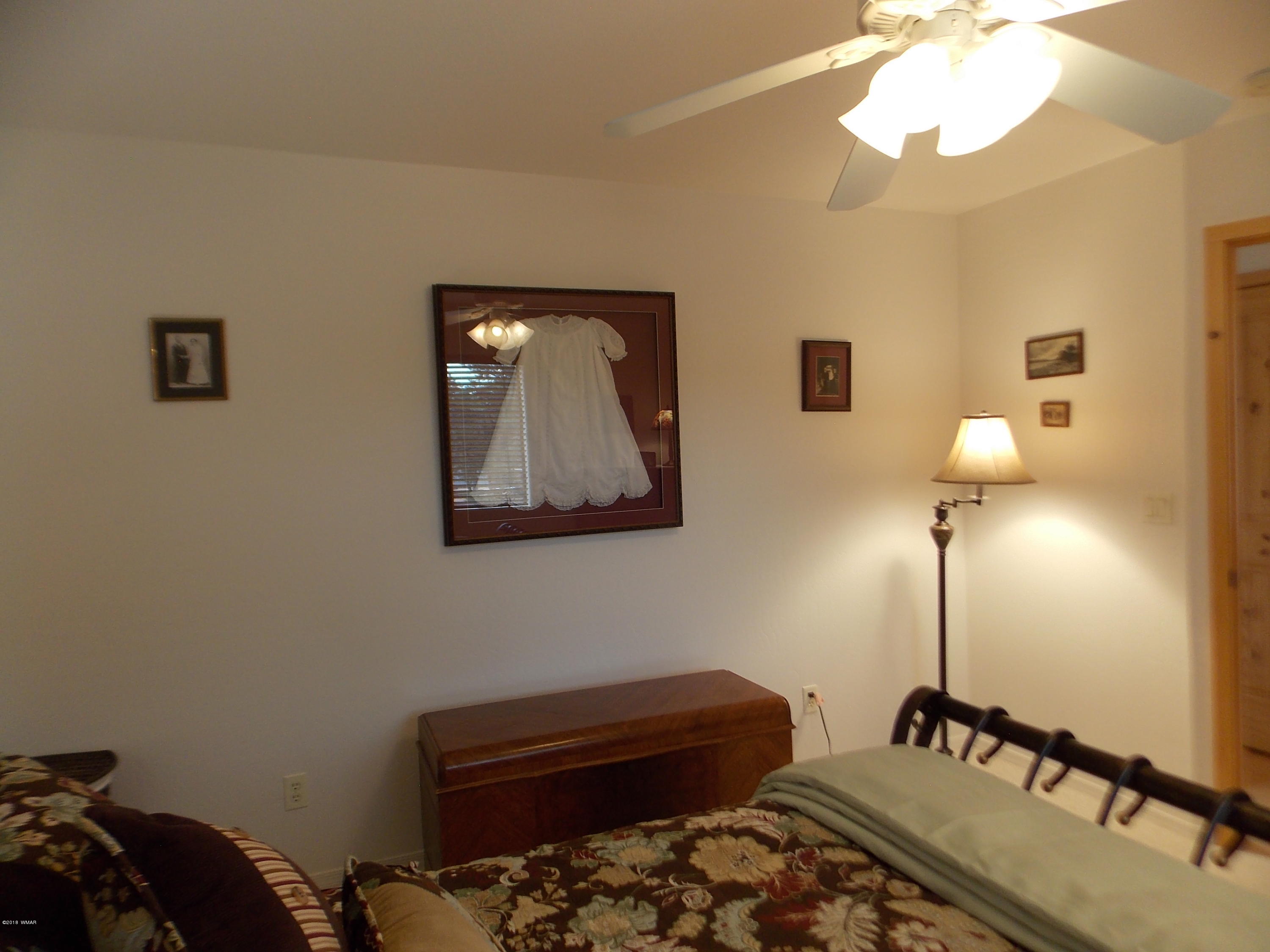 2296 Sunrise Road Overgaard, AZ 85933 - Photo 38 of 66 a bedroom with a bed and a lamp