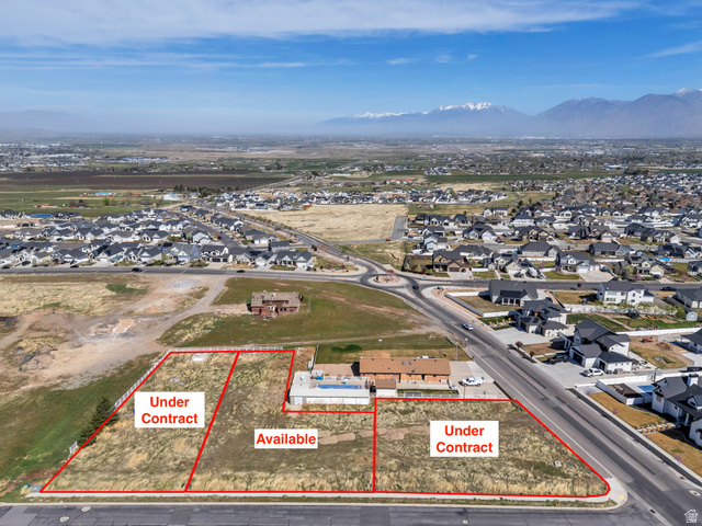 Aerial perspective of suburban area featuring property parcel outlined and a mountain backdrop