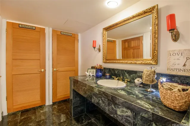 a bathroom with a granite countertop sink a mirror and shower
