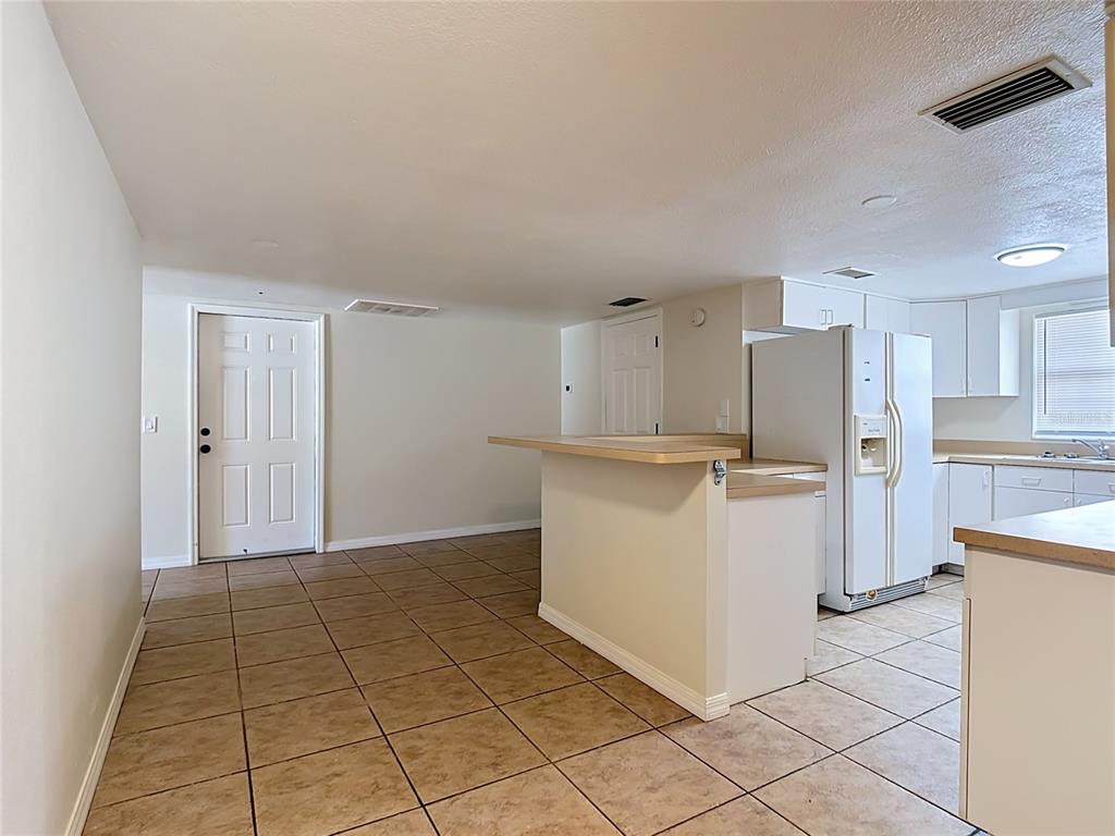 7925 Lake Mabel Loop Road Lake Wales, FL 33898 - Photo 66 of 97 a view of a kitchen with refrigerator and white cabinets