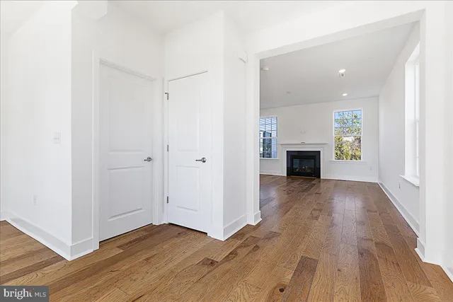 a view of empty room with wooden floor and fireplace