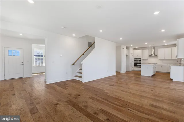 a view of kitchen with kitchen island white cabinets and wooden floor