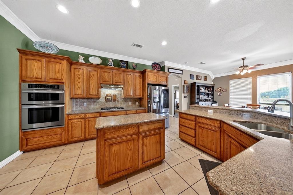 1035 Highland Road Cleburne, TX 76033 - Photo 3 of 36 a kitchen with stainless steel appliances granite countertop a stove and cabinets