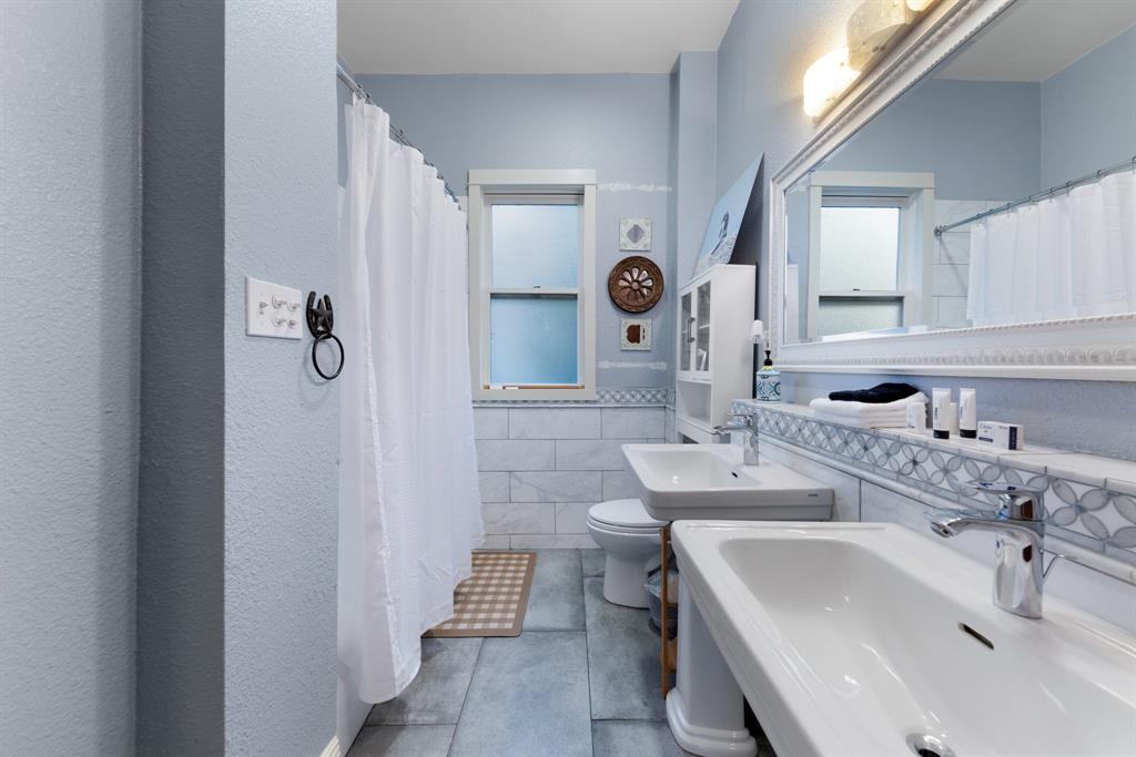 5502 Victor Street Dallas, TX 75214 - Photo 15 of 22 a bathroom with a sink and a mirror