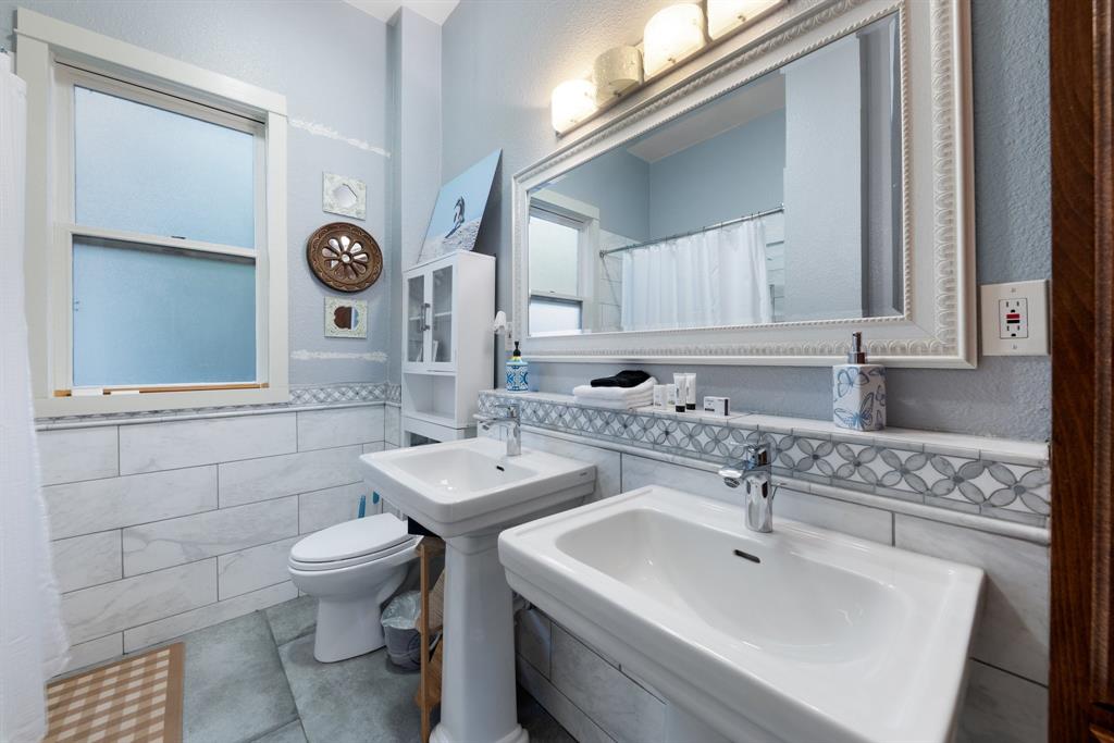 5502 Victor Street Dallas, TX 75214 - Photo 16 of 22 a bathroom with a toilet sink and mirror
