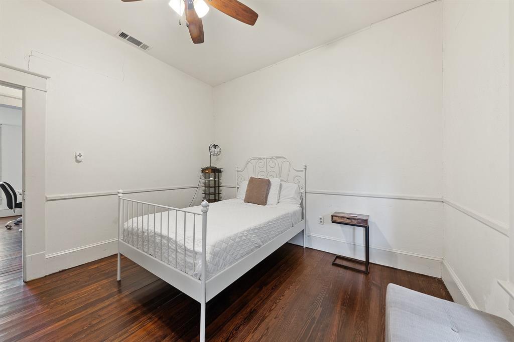 5502 Victor Street Dallas, TX 75214 - Photo 20 of 22 a bedroom with a bed and wooden floor