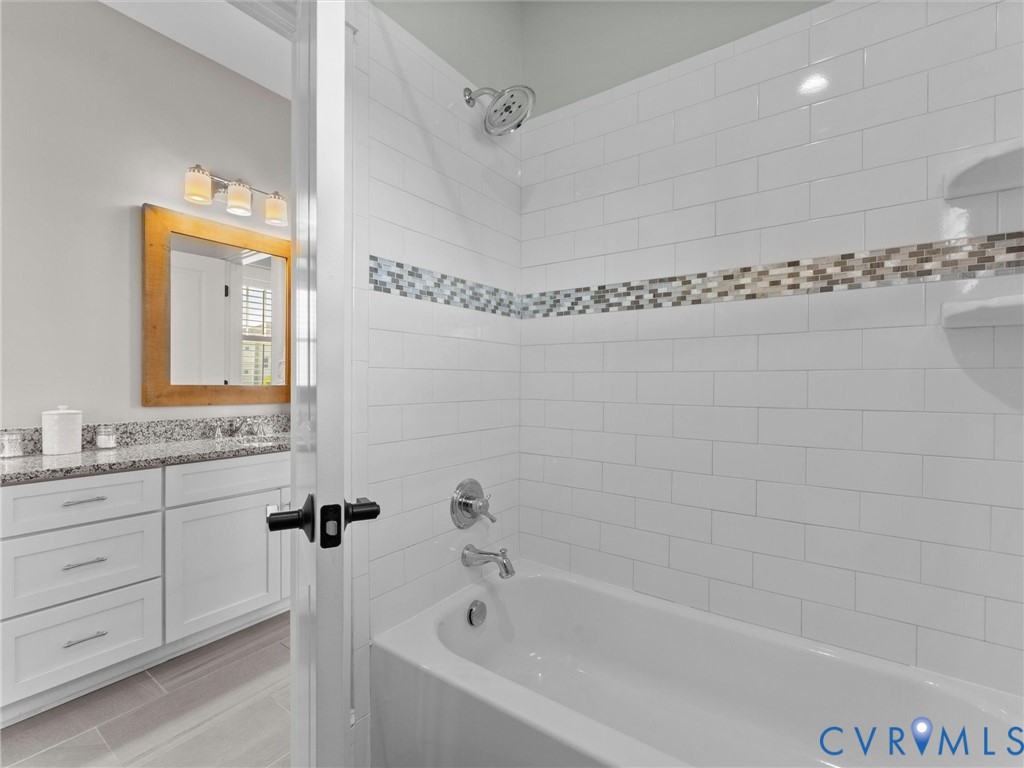 1925 Limbeck Lane Midlothian, VA 23112 - Photo 51 of 89 a bathroom with a granite countertop sink a mirror and a bathtub