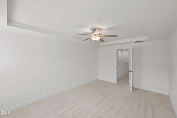 an empty room with a chandelier fan