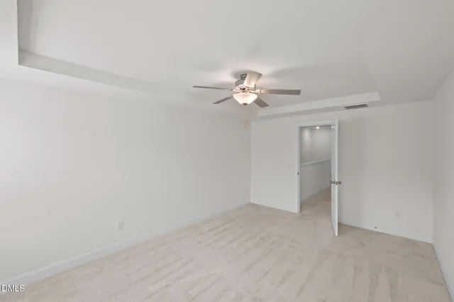 an empty room with a chandelier fan